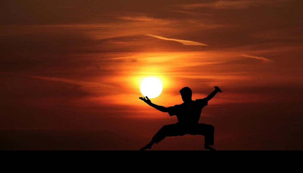 Person practicing yoga on a mountaintop with scenic natural views, symbolizing mental clarity and inner peace.